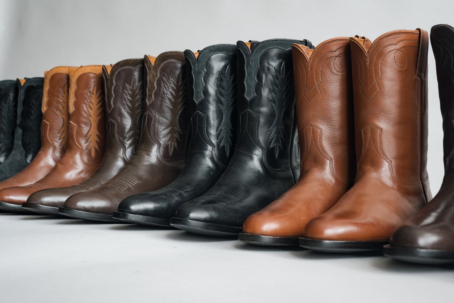 Row of brown and black boots on display