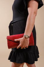 Red alligator leather Catalina clutch carried by hand